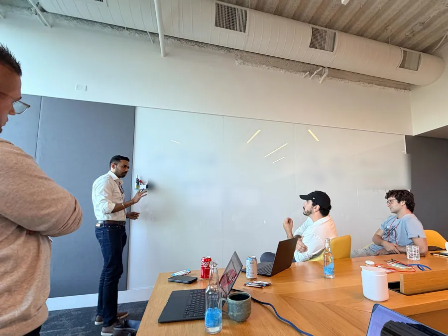 A CWX working session at a whiteboard, with the team around the table