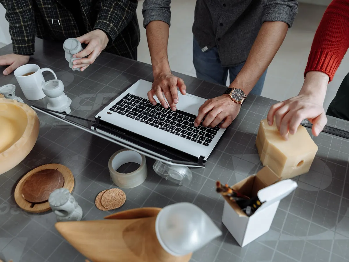 A team sketching a product on a laptop and paper