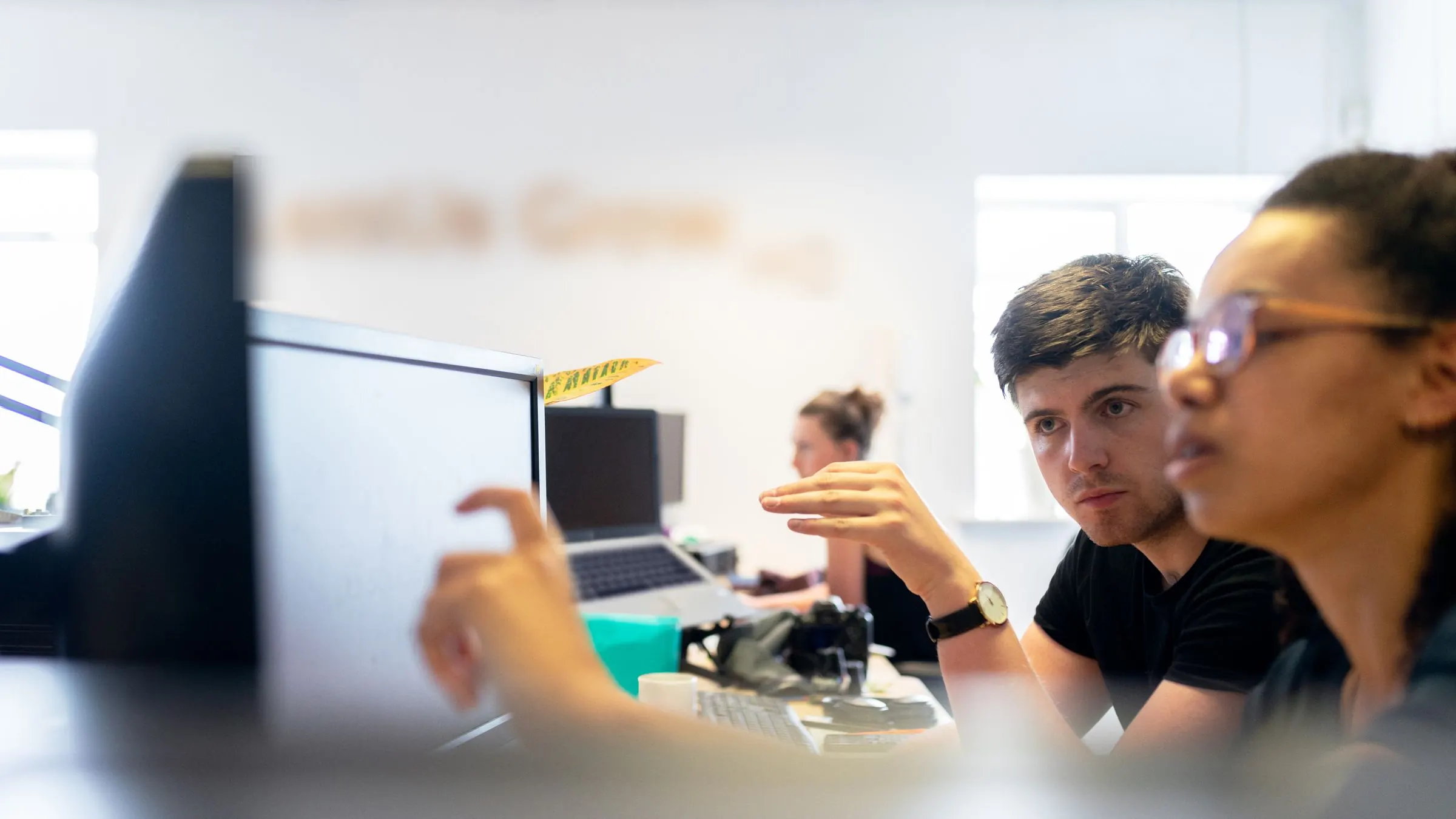 Two engineers talk through a build at their screens