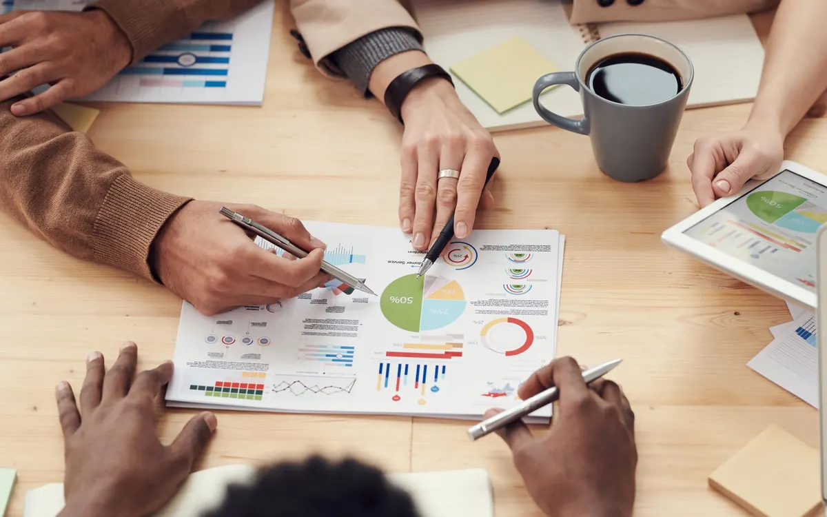 Hands pointing at printed charts on a meeting table