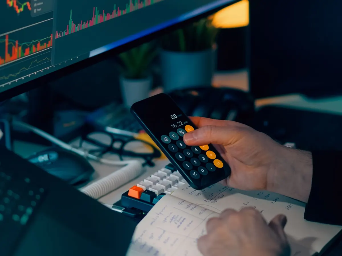 Financial results on a monitor beside a calculator