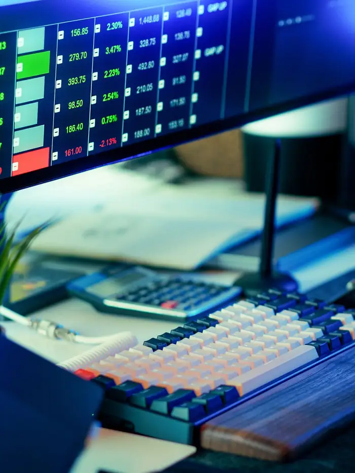 Trading and analytics dashboards glowing on screens in a dark office