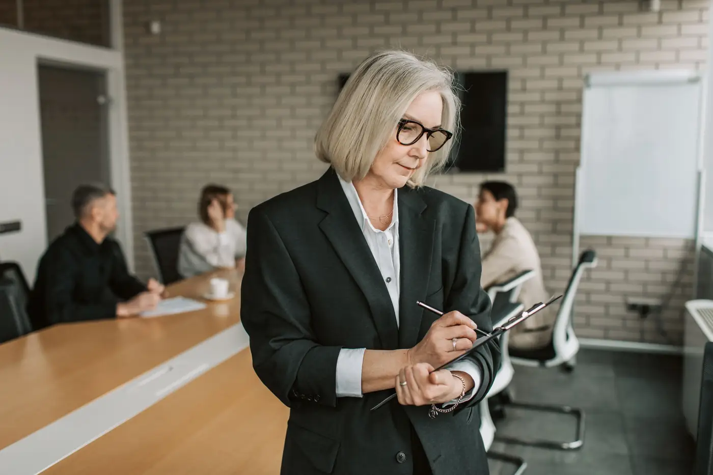 A senior executive reviews notes during a team meeting